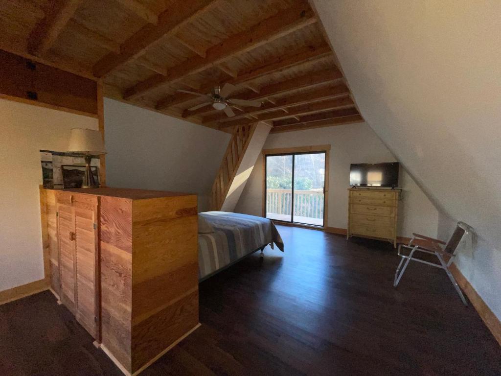 ein Schlafzimmer mit einem Bett, einer Kommode und einem Fenster in der Unterkunft Relaxing Creek Cabin in Canton