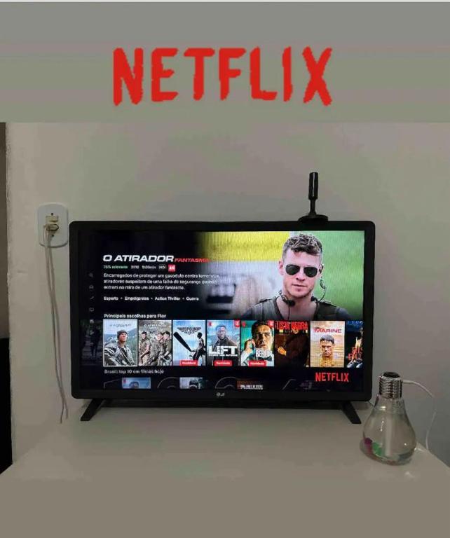 TV a/nebo společenská místnost v ubytování Cantinho Aconchegante- Quarto 03 Família - com AR