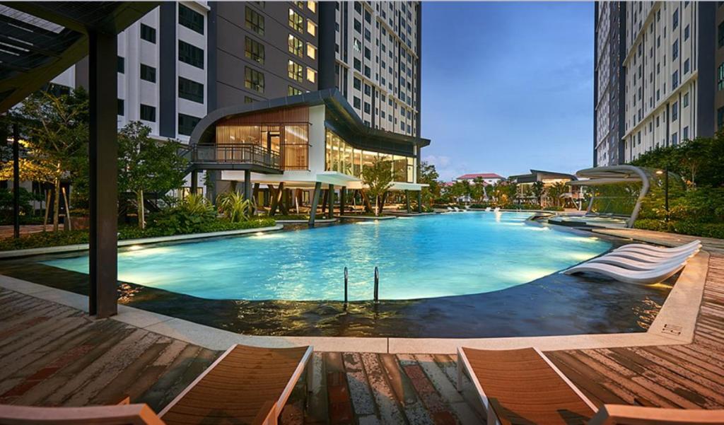 a large swimming pool with chairs and buildings at M Centura Sentul KL Fully Air Con Blissful Suite KL in Kuala Lumpur