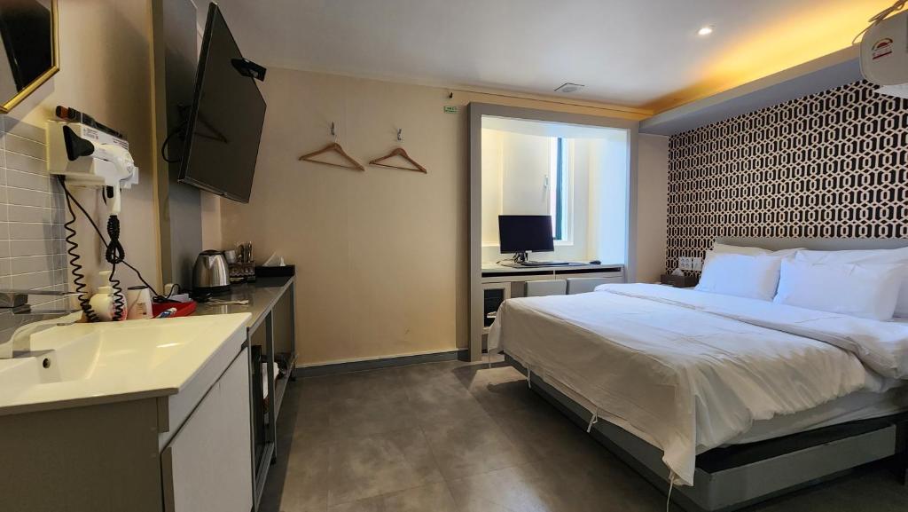 a bedroom with a bed and a sink and a bathroom at Let's Stay in Seoul