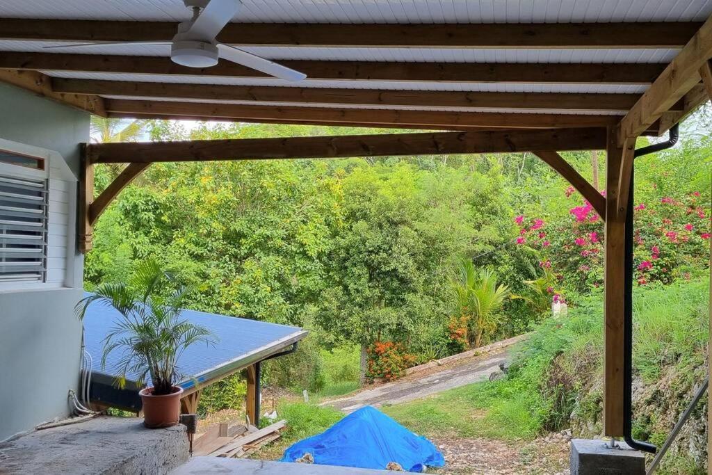 a patio with a ceiling fan and a table at L'ambre in Deshauteurs