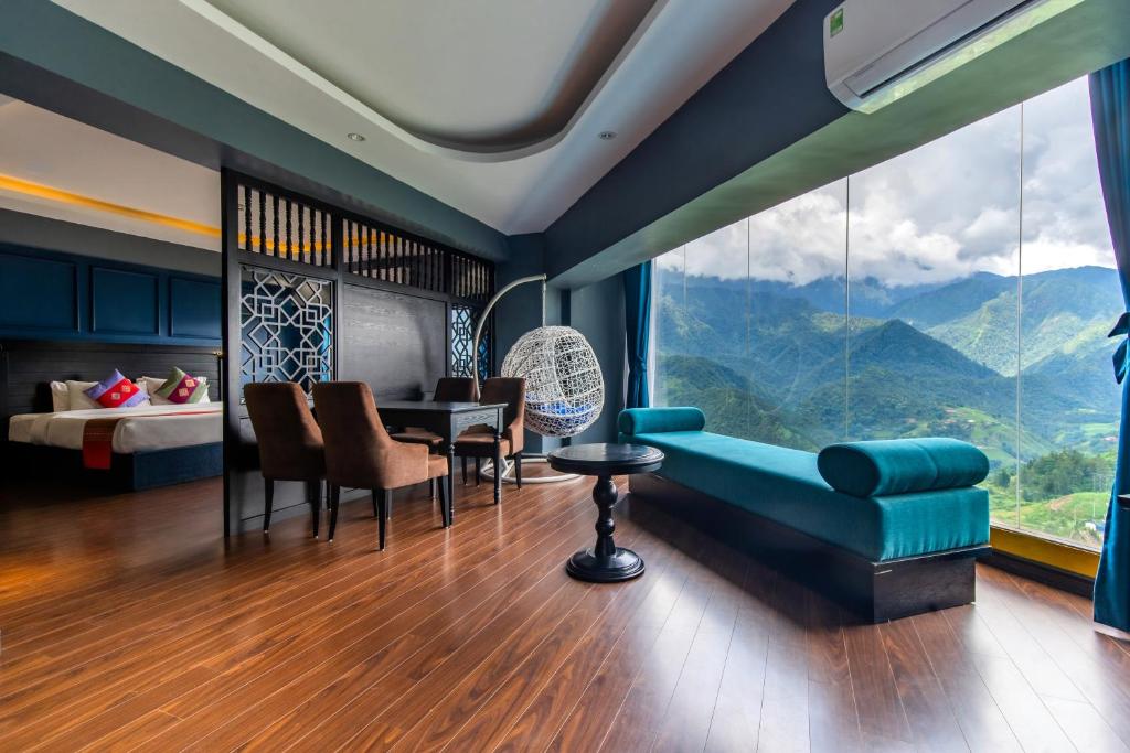 a living room with a blue couch and a table at Sapa Charm Hotel in Sapa