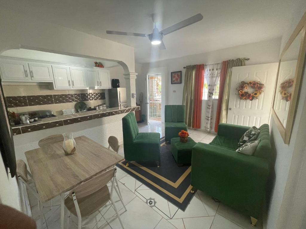 a living room with a table and green chairs at Apartamento acogedor in Sabana Grande