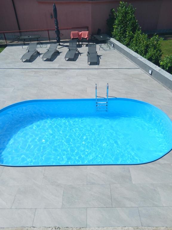a blue swimming pool with a table and chairs at Maja in Velika Gorica