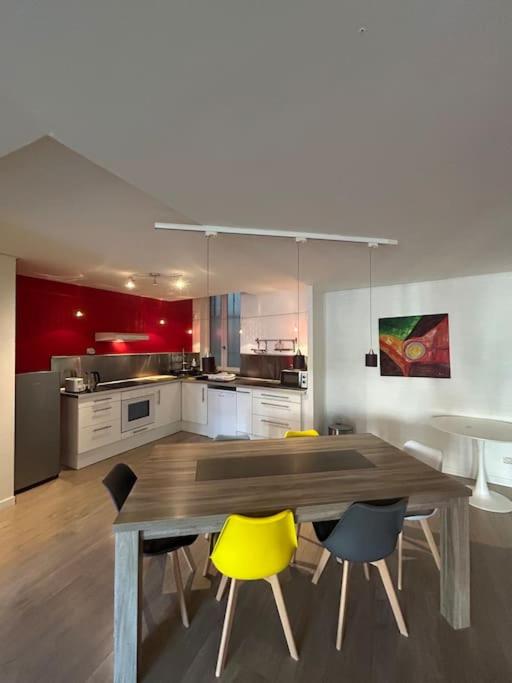 une cuisine avec une table en bois et des chaises jaunes dans l'établissement L'Empereur 6p climatisation, à Montauban