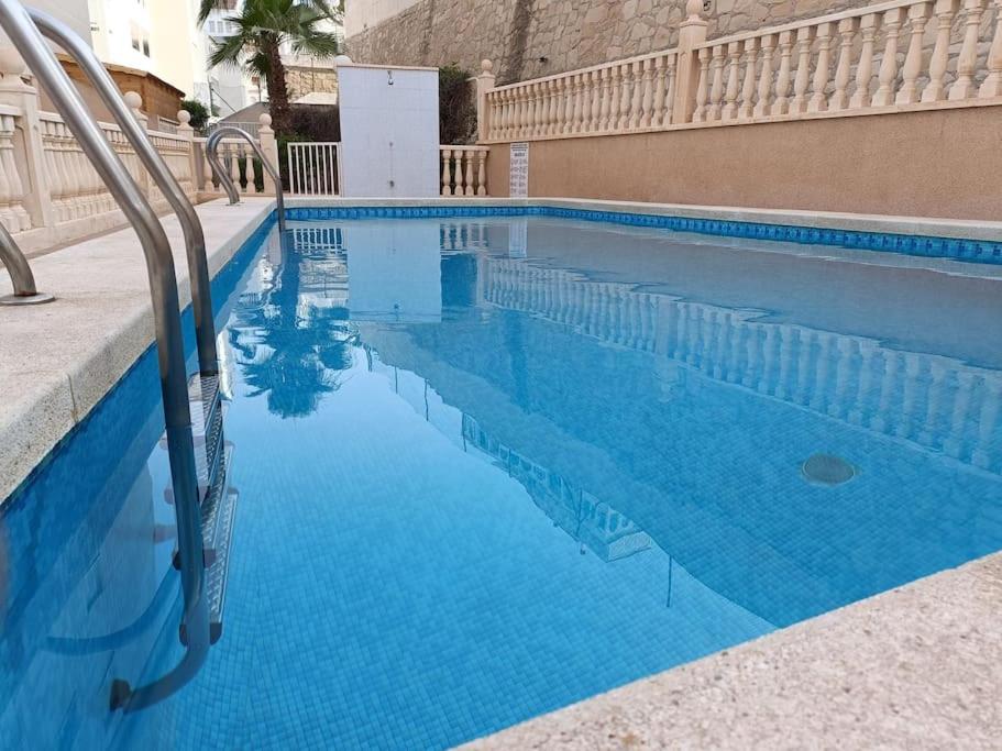 a swimming pool with blue water in a building at Galatea Arena in Arenales del Sol