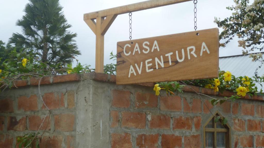 Ein Zeichen, das zeigt, wie Casa eventina über einer Ziegelmauer hängt. in der Unterkunft Casa Aventura in San Clemente