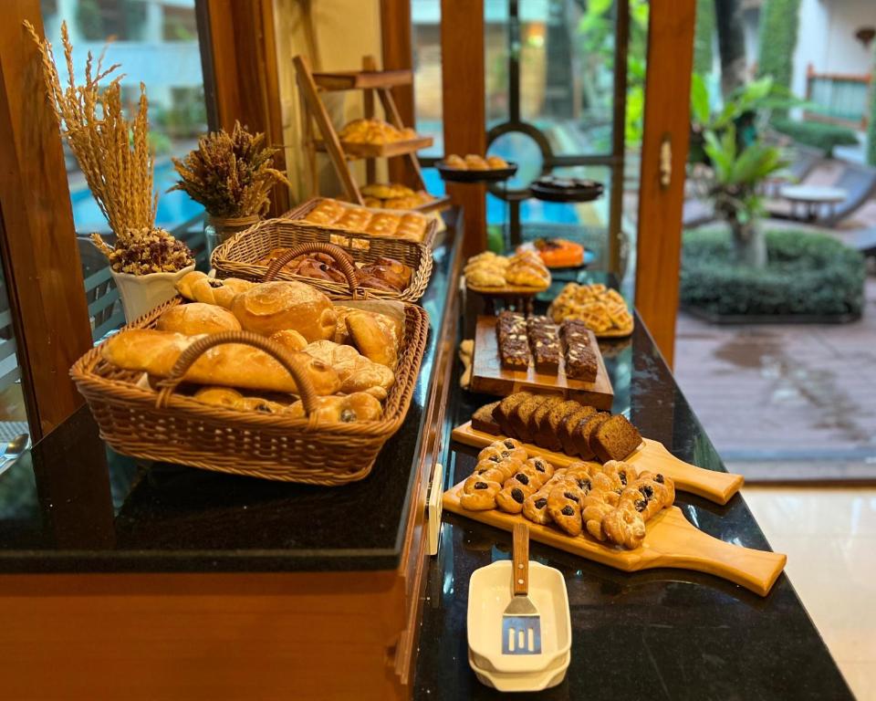 A broad pastry and bread display beside garden-facing windows.