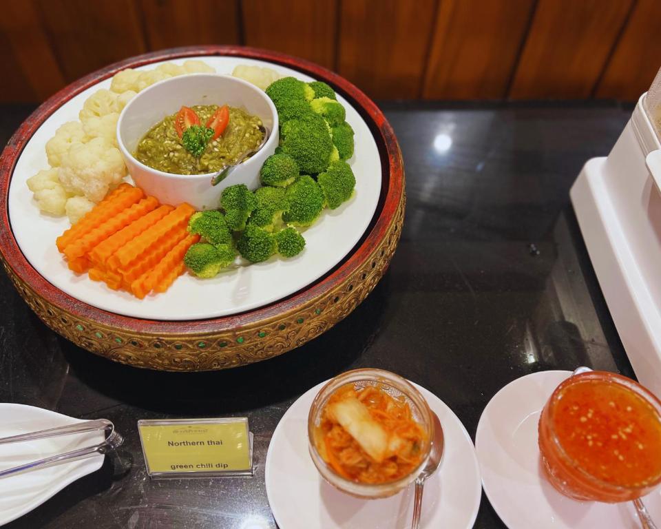 A buffet plate of vegetables with dipping sauces and a Northern Thai label.
