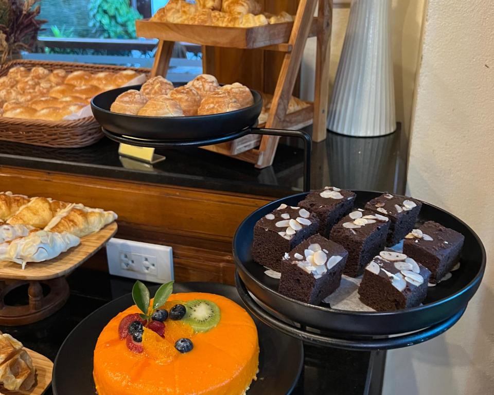 A buffet display of pastries, chocolate cake and fruit cake.