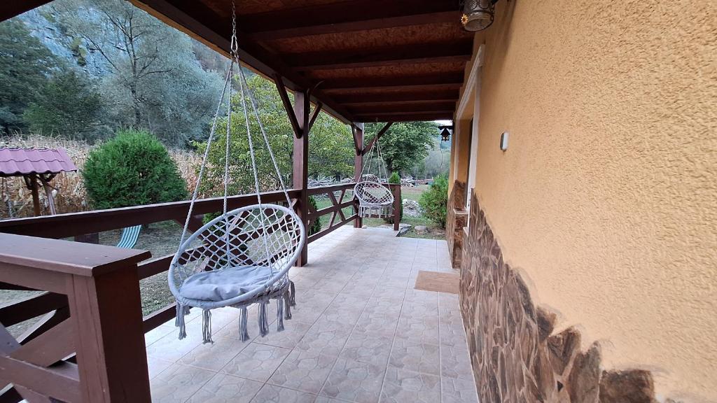 a porch with two chairs and a porch swing at Casa de vacanta Bulz in Bulz