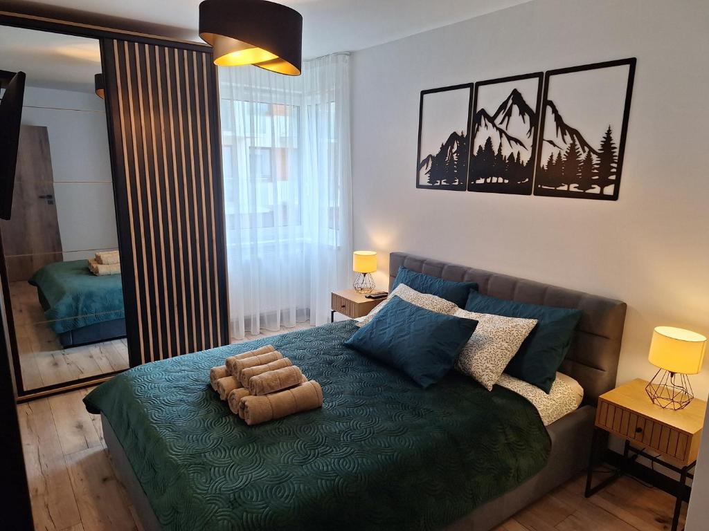 a bedroom with a bed with a green comforter at Apartament KarkonoSKI in Karpacz