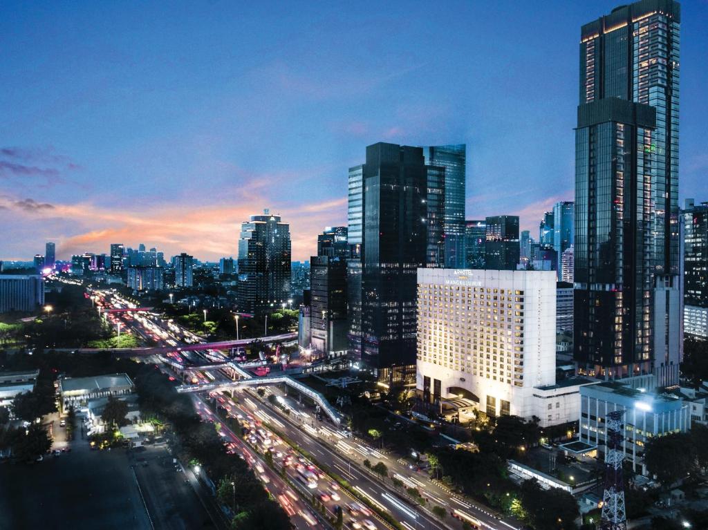 a city skyline at night with traffic on a highway at Mangkuluhur ARTOTEL SUITES in Jakarta