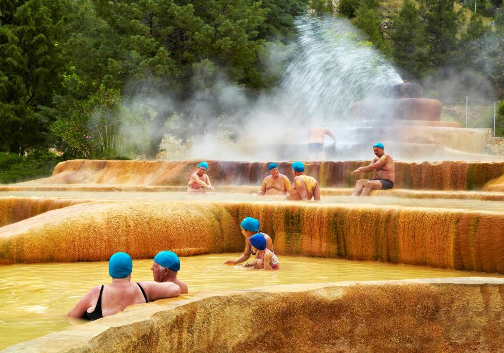 a group of men in the water in a waterfall at Pam Thermal Hotel Clinic & Spa in Pamukkale