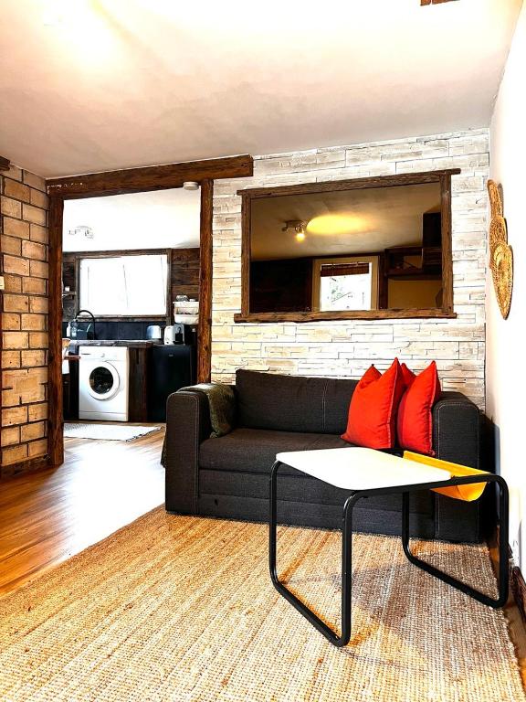 a living room with a black couch and red pillows at Appartement les Sapineaux in Courchevel