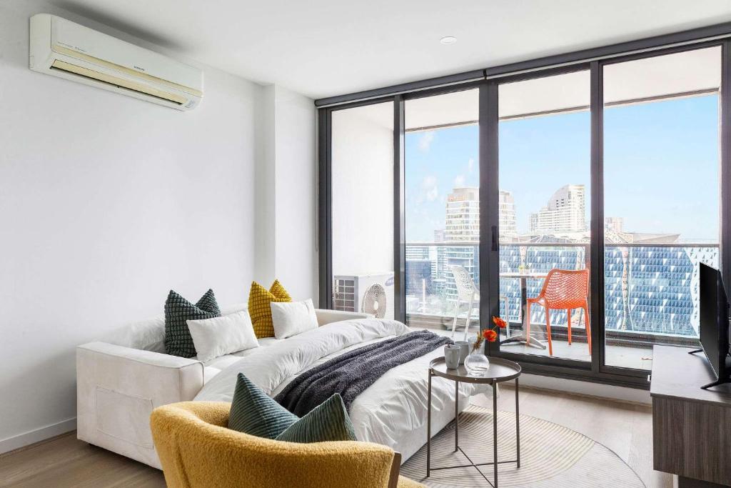 a living room with a white couch and a large window at A 2BR Apt with Harbour Views and FREE Parking in Melbourne