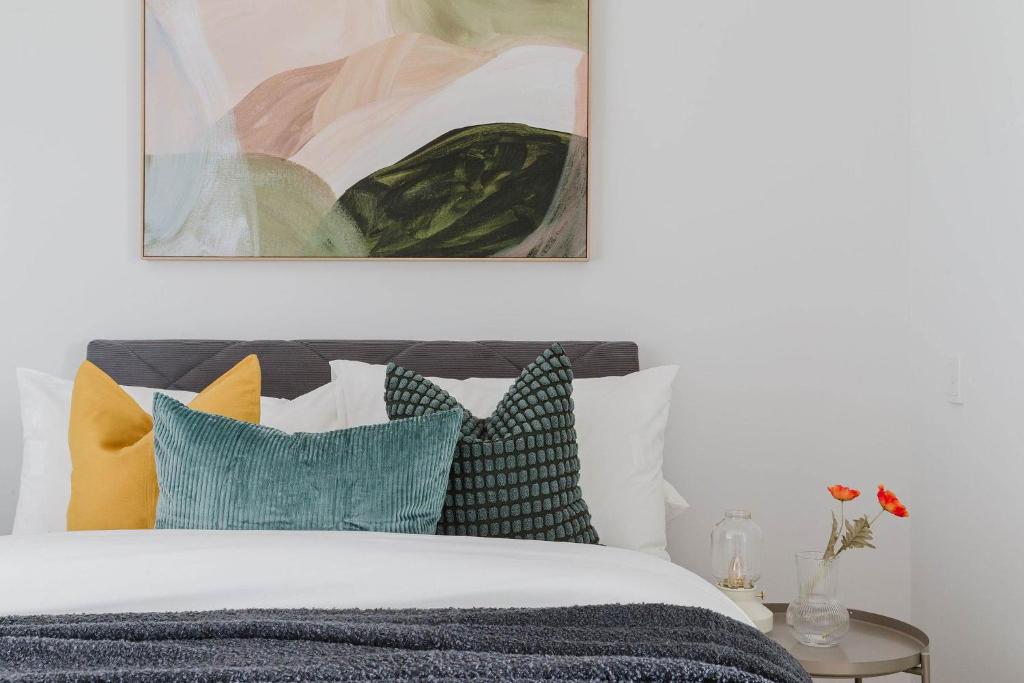 a bedroom with a bed with colorful pillows at A 2BR Apt with Harbour Views and FREE Parking in Melbourne