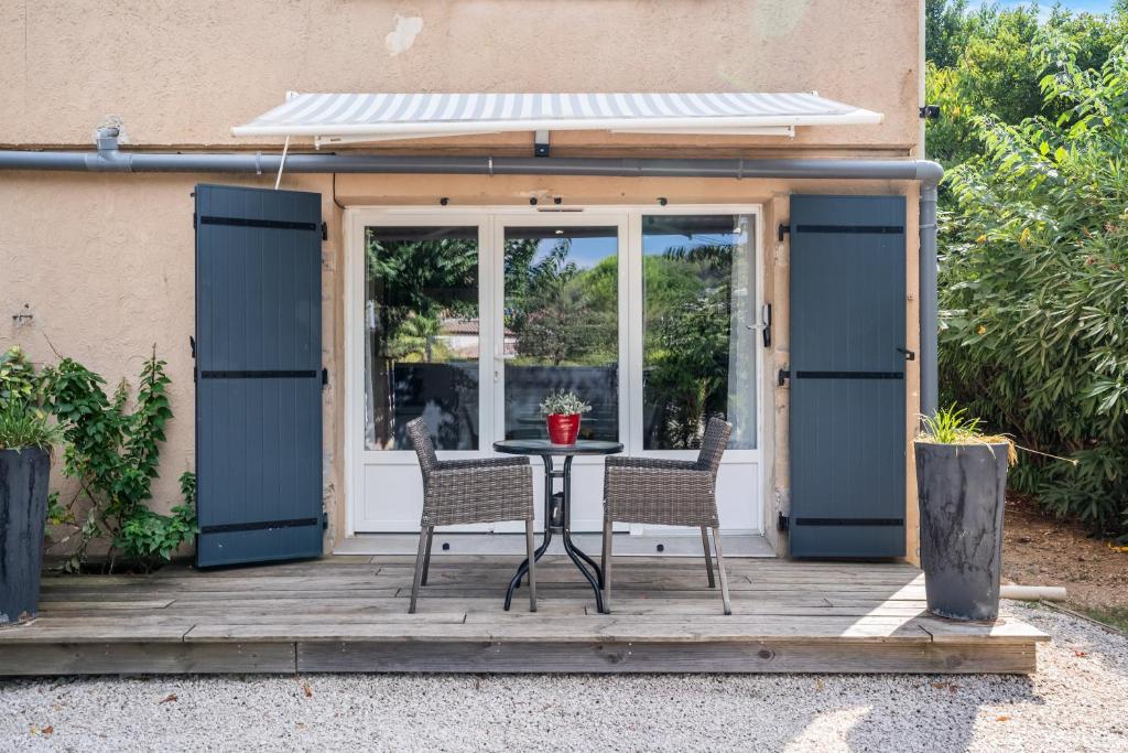 un patio avec une table et des chaises devant un bâtiment dans l'établissement Villa Nui, à Cuers