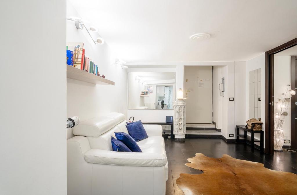 a living room with a white couch and blue pillows at Spinola Palace Apartment in Genoa