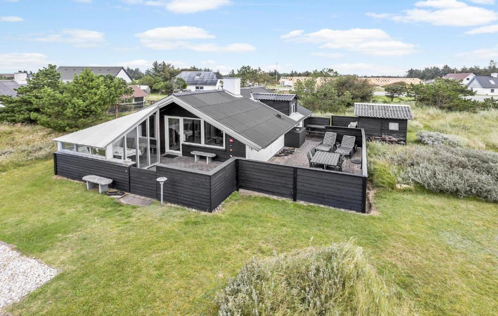 a large black house on a grass field at 2 Bedroom Amazing Home In Thisted in Thisted