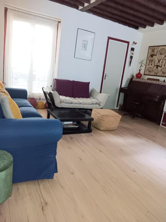 un salon avec un canapé bleu et une table dans l'établissement Home sweet home Paris, à Paris