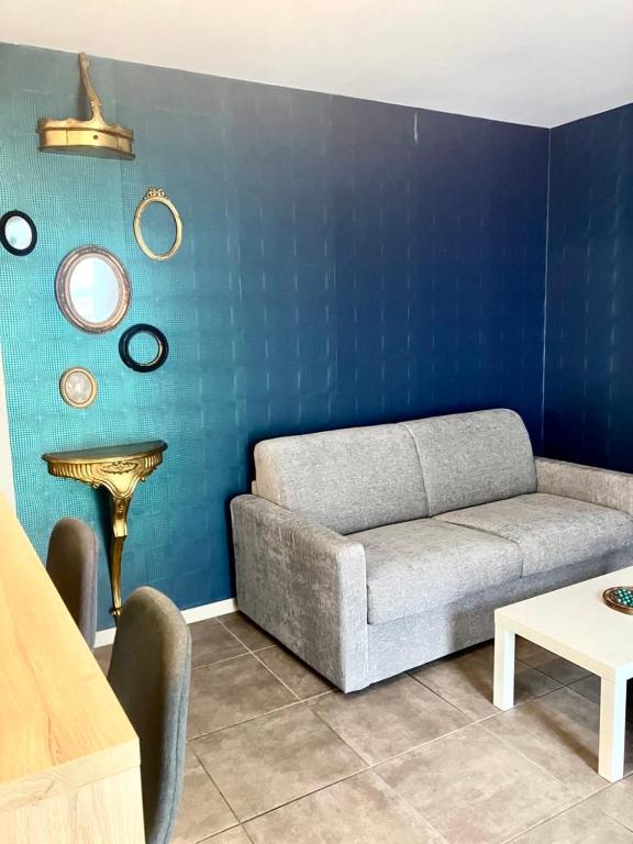 a living room with a couch and a blue wall at Chez Prunette in Belleville-sur-Meuse