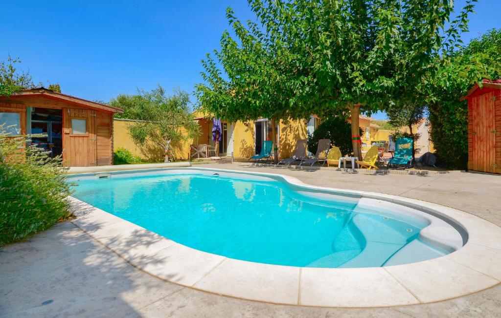 a swimming pool in a yard with a tree at Awesome Home In Marguerittes With Wifi in Marguerittes