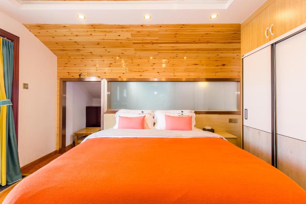 a bedroom with a large orange bed with wooden walls at 桂林依庐居民宿 in Guilin