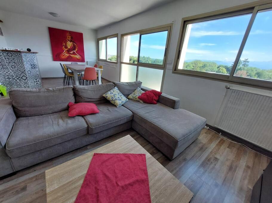 un salon avec un canapé et une table dans l'établissement le Pradeau - T3 panorama Pyrénées, à Tarbes