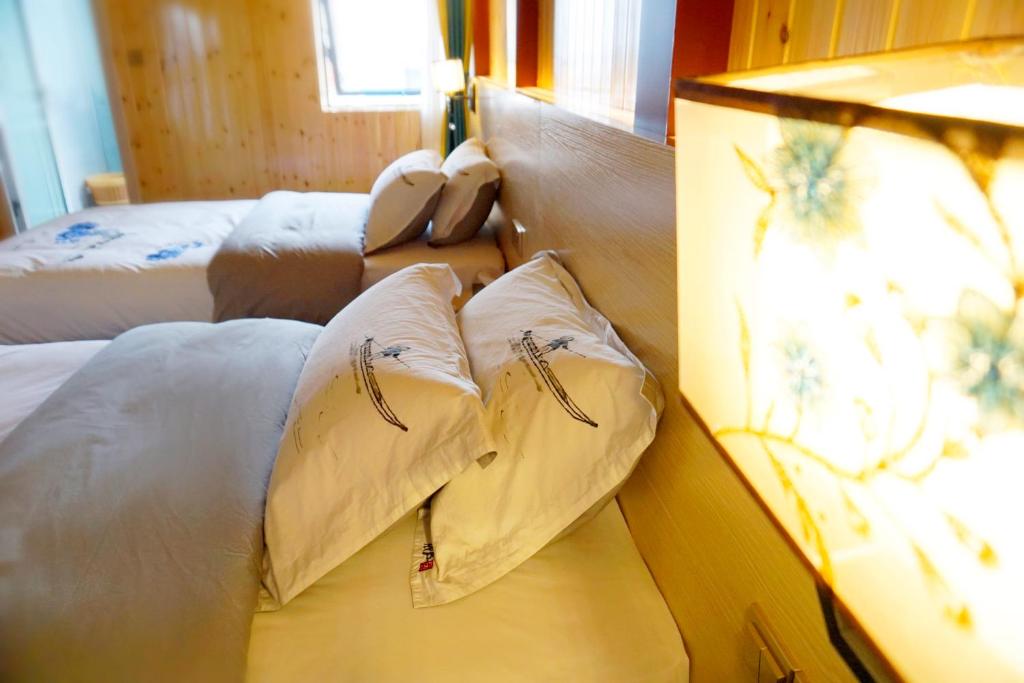 a bed with two pillows on it in a room at 桂林依庐居民宿 in Guilin