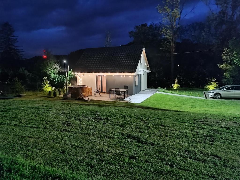 a white house with a lawn in front of it at Przystanek Leszczyniec w Sudetach z jacuzzi - za dopłatą in Leszczyniec