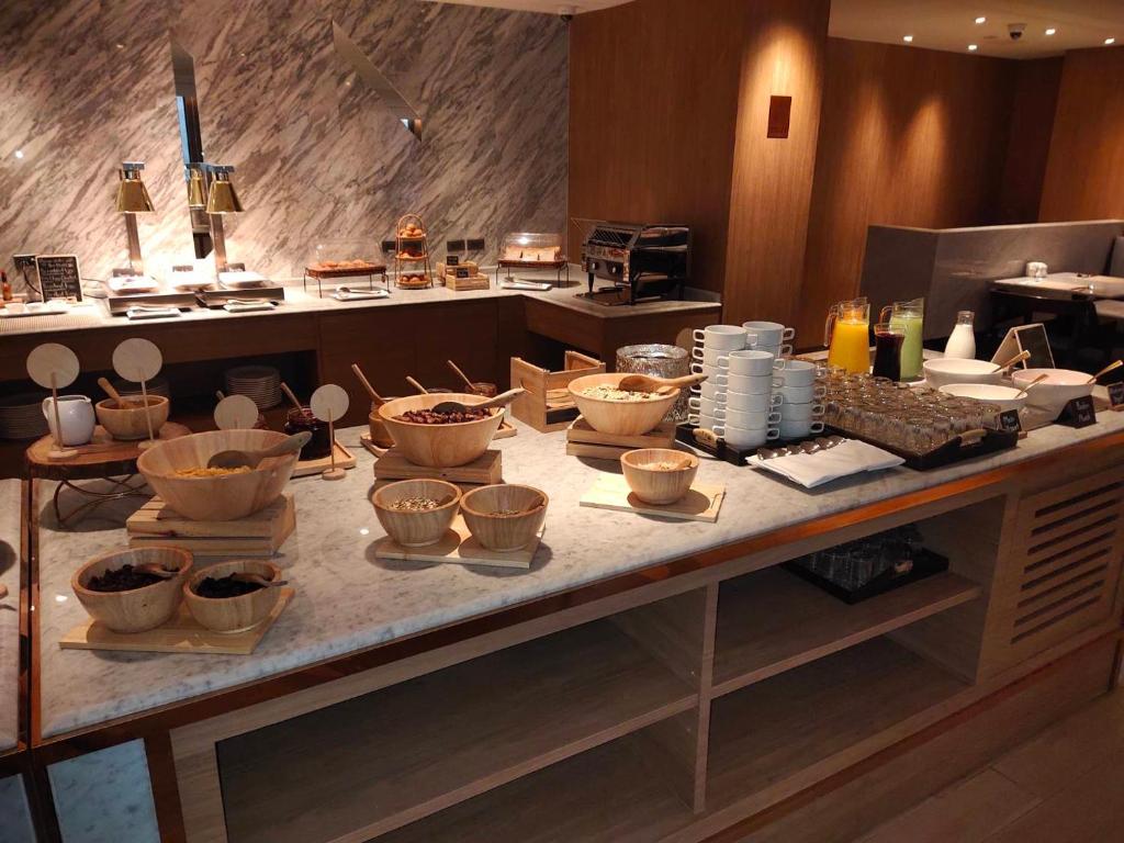 A breakfast station with bowls, pastries, drinks and a full coffee setup.