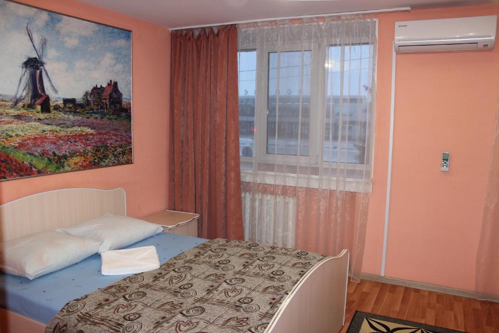 鄂木斯克的住宿－Aero Hotel，一间卧室,配有一张床和风车画