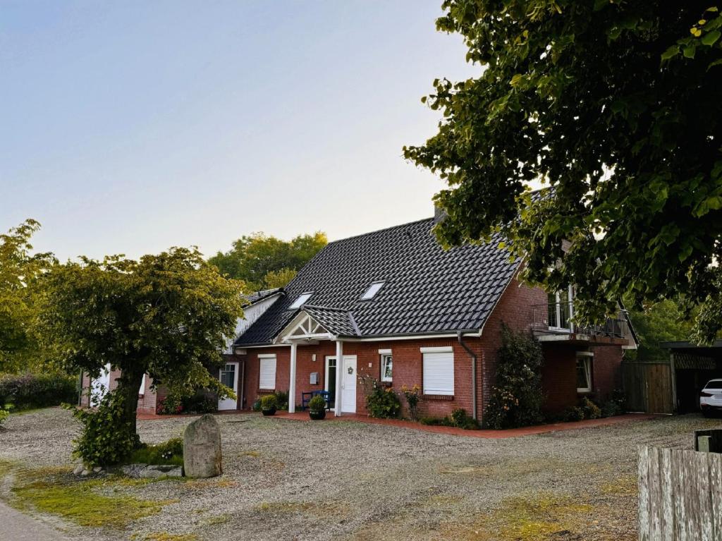 a red brick house with a black roof at Ostseehuus Apartment I in Steinbergkirche