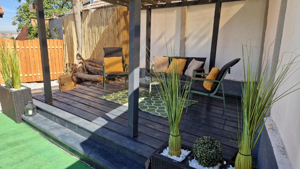 a patio with a couch and chairs and plants at Dominic House in Turda