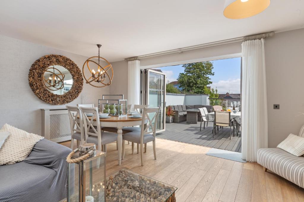 a living room with a table and chairs and a patio at Ger Y Mor - Village Centre with Parking in Saundersfoot