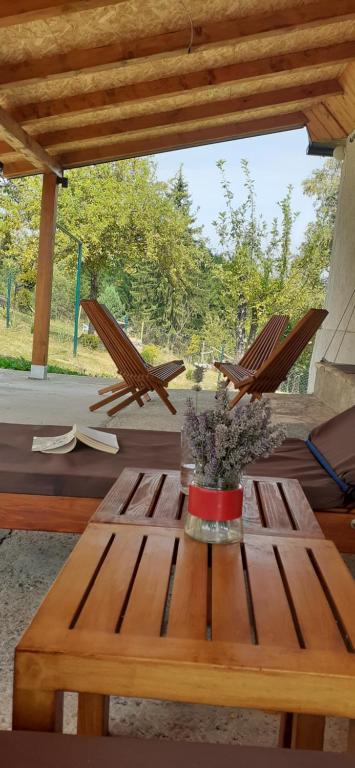 a wooden table with two chairs on a patio at Tara Suncani sjaj-planinska kuca in Šljivovica