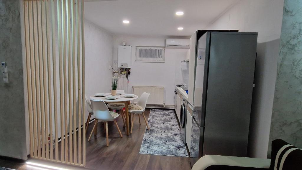 cocina pequeña y comedor con mesa y sillas en Dominic House, en Turda