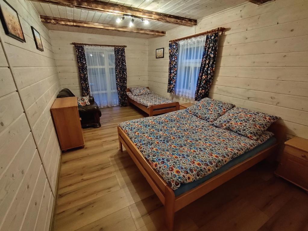 a bedroom with a bed in a wooden cabin at Wehikuł Czasu in Jędrzejówka