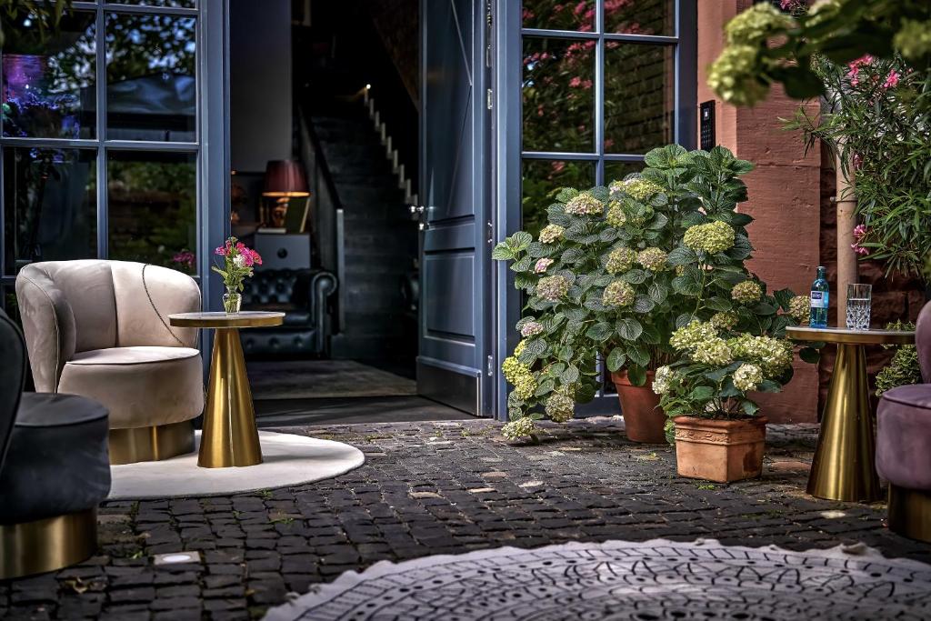 eine Terrasse mit Tischen, Stühlen und Pflanzen in der Unterkunft Boutique Suites and Residences Heidelberg- Alte Zigarrenmanufaktur in Heidelberg