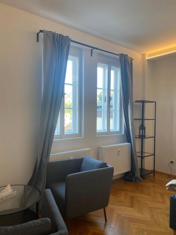 a living room with a couch and two windows at Apartmán v centru Krumlova in Český Krumlov