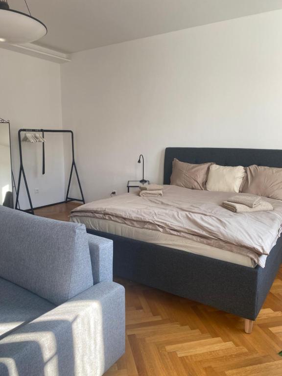 a bed in a room next to a couch at Apartmán v centru Krumlova in Český Krumlov