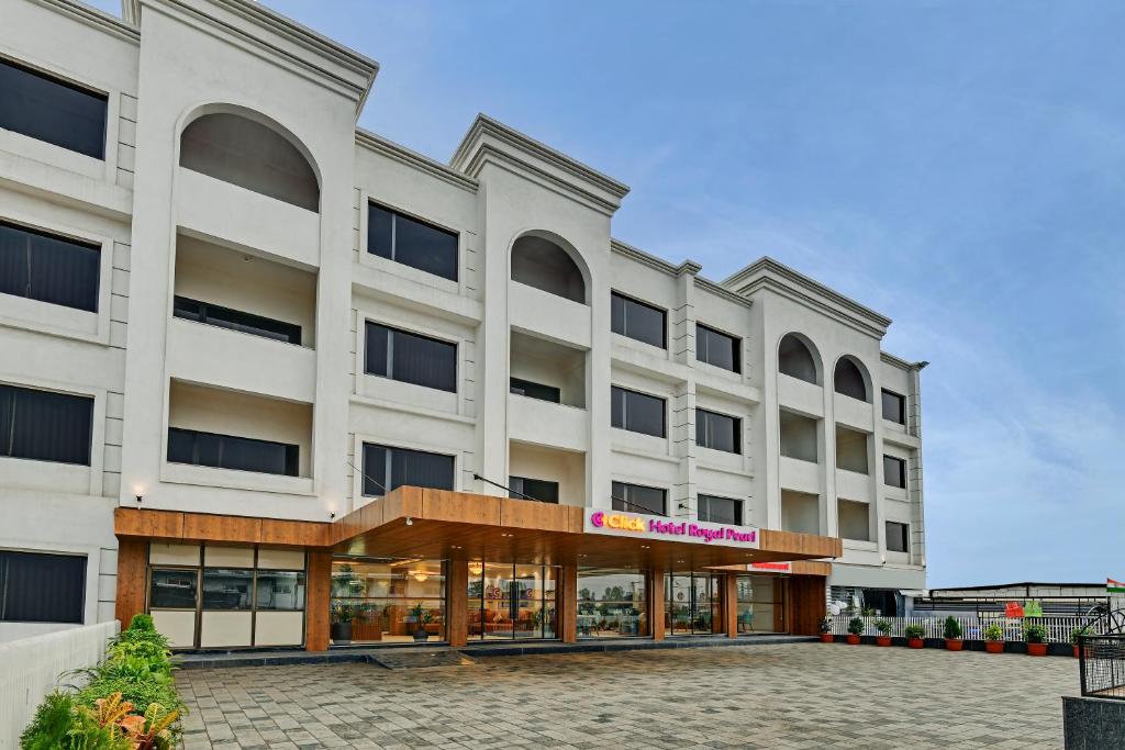a large white building with a sign on it at Click Hotel Royal Pearl, Galenda, Dahej in Dahej
