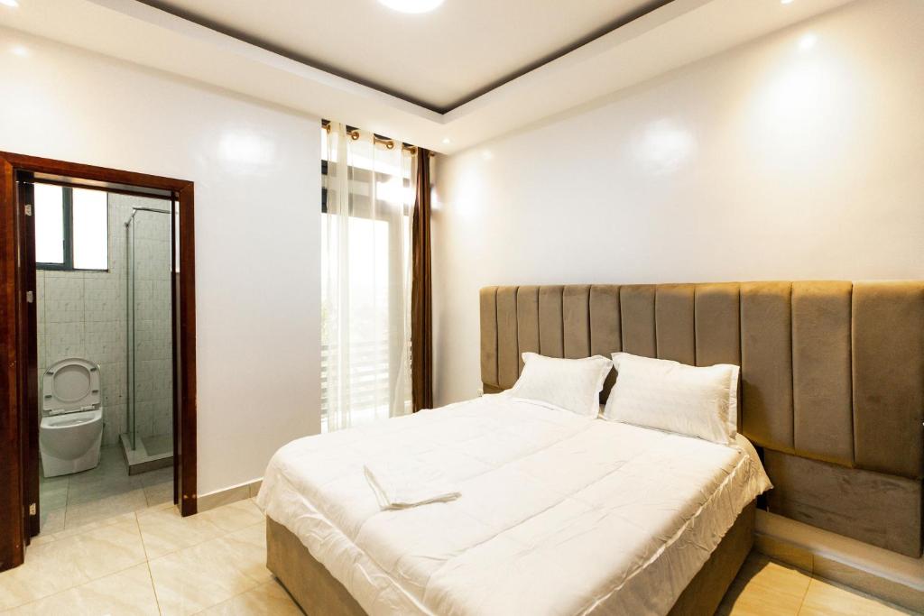 Postel nebo postele na pokoji v ubytování Laurus Apartments Kigali
