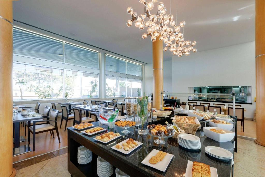 a dining room with a table filled with food at TRYP by Wyndham Porto Expo Hotel in Leça da Palmeira