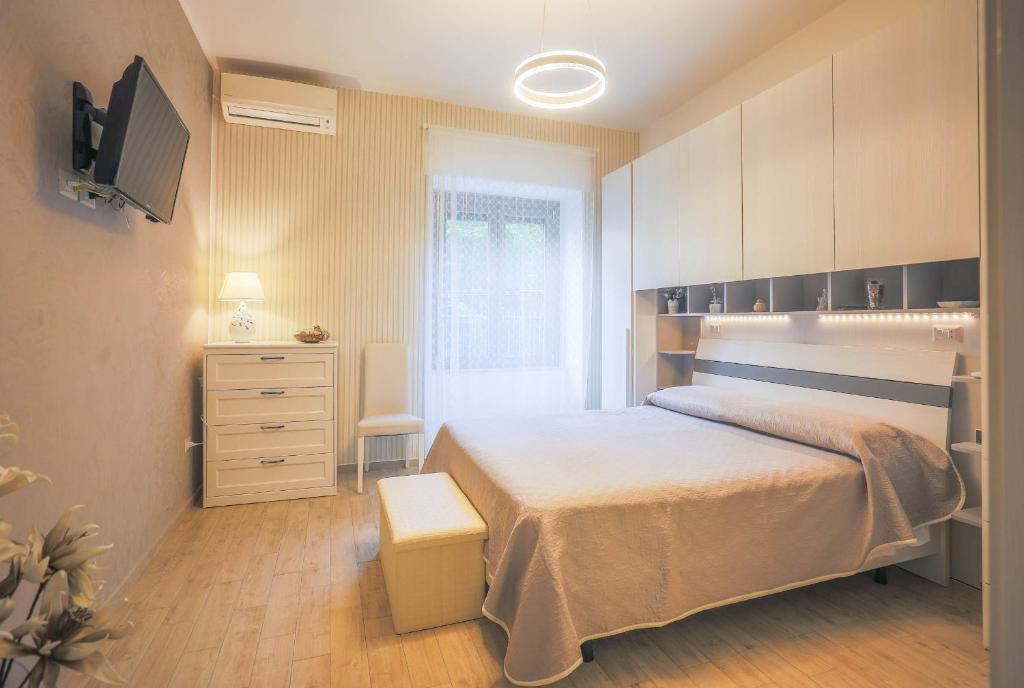 a bedroom with a bed and a dresser at Primavera Guest House - In Centro, Vicino Aeroporto, Salerno e Paestum in Pontecagnano