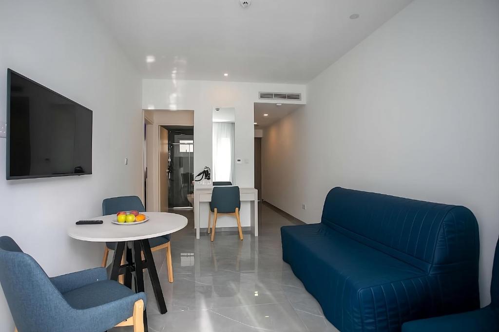 a living room with a blue couch and a table at Best Western Plus Larco Hotel in Larnaka