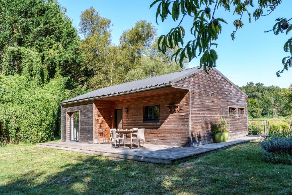 une petite cabane en bois avec une terrasse dans une cour dans l'établissement La cabane du pont du Douet, à Mazières-de-Touraine