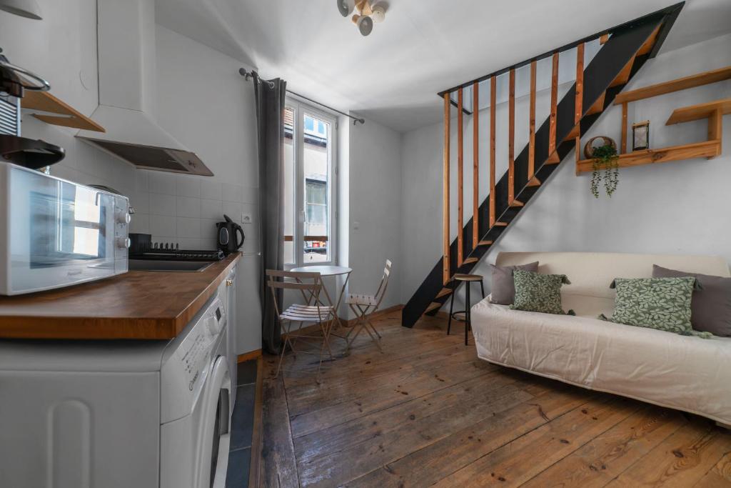 a kitchen and living room with a couch and stairs at Cosy & Duplex - Appartements au coeur de la vieille Ville in Clermont-Ferrand