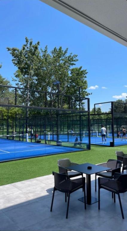 a patio with a table and chairs and a tennis court at Chrysomare Beach Hotel & Resort in Ayia Napa